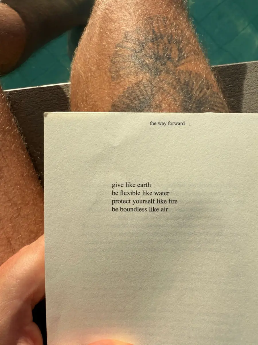 A printed poem, “the way forward,” held by a pool