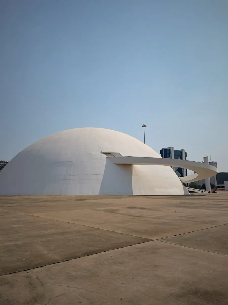 The white dome and curving ramp of the National Museum in Brasília under a clear sky